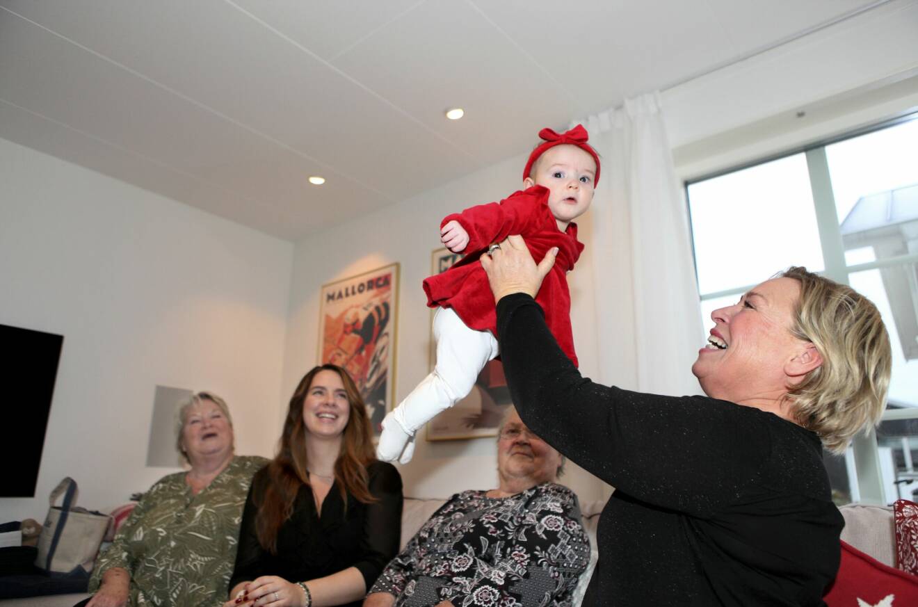 Heléne Kinnervall lyfter upp sitt barnbarn Zoe i luften, de är en del av fem generationer kvinnor.