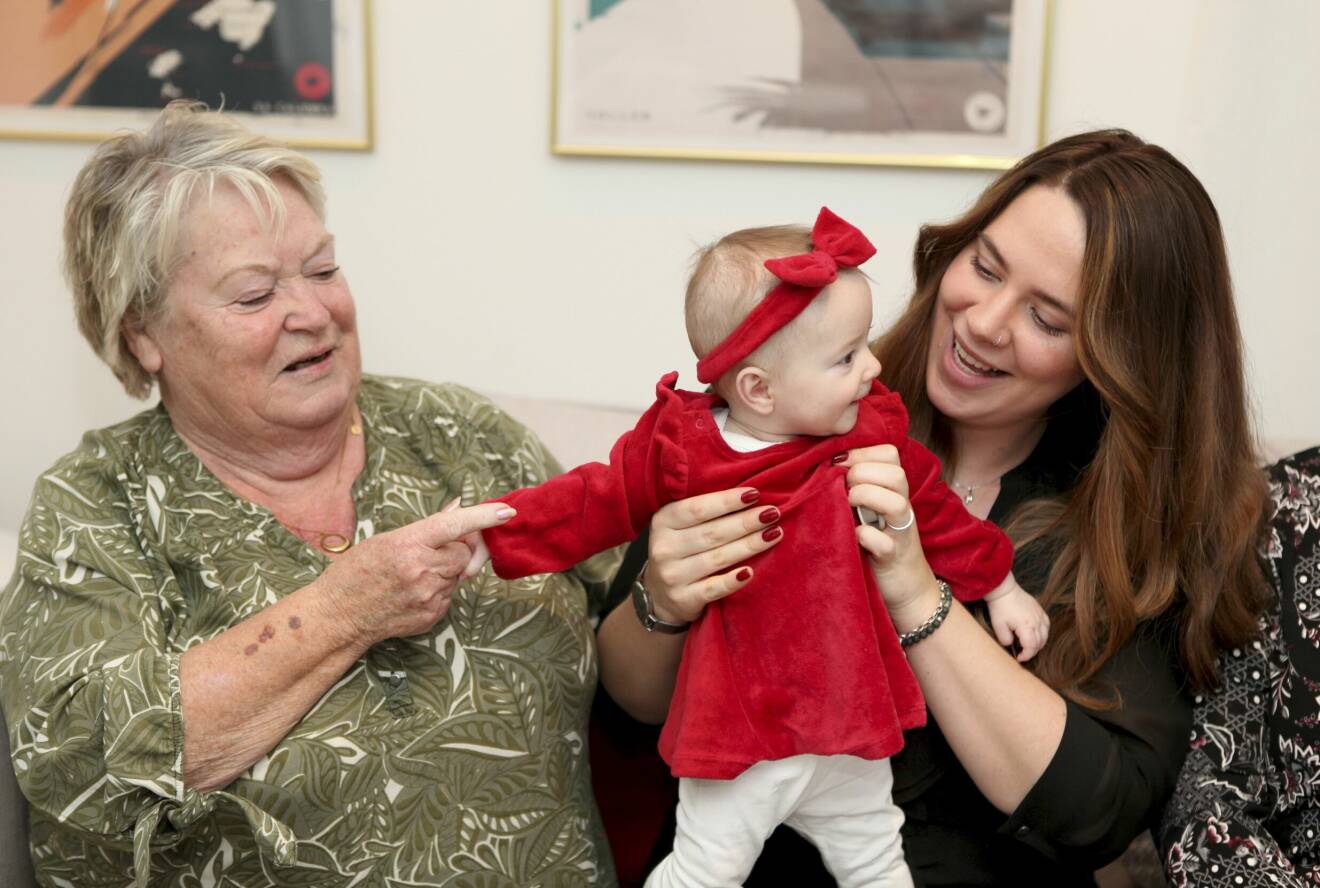 En leende Lisbeth Kinnervall med sitt barnbarn Sarah Storm och hennes glada lilla dotter Zoe Storm med röd rosett på huvudet.