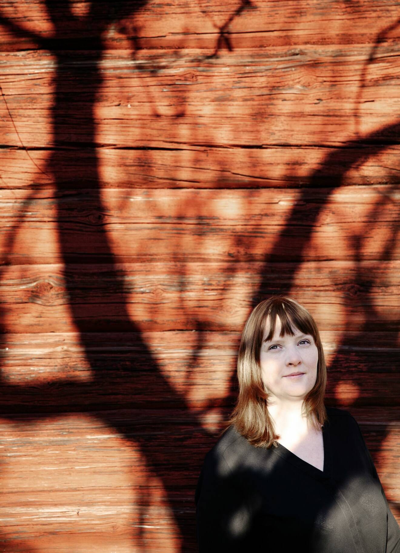 När författaren Karin Janson var 22 år fick hon veta att hon har en sköldkörtelsjukdom. Här vid en solkysst faluröd timmervägg.