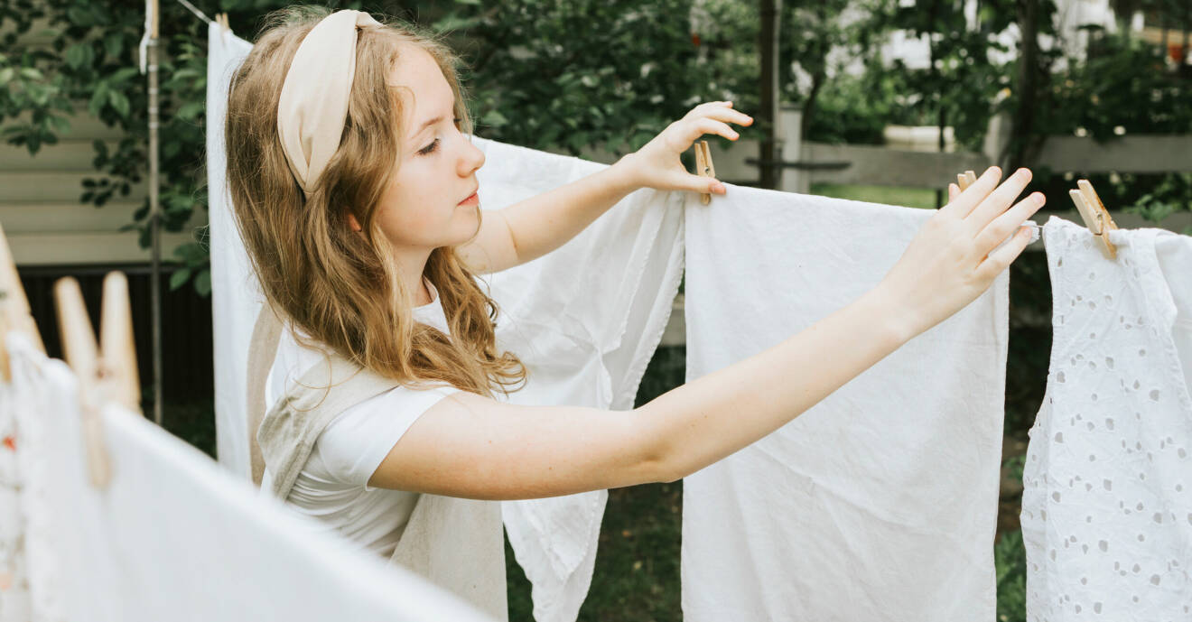 Ung kvinna som hänger tvätt på tvättlina