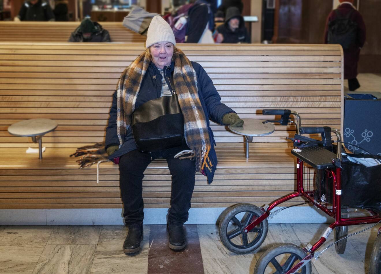 Eva Larsson sitter på en bänk på Stockholms centralstation där hon tillbringade mycket tid under sina nio månader som hemlös.