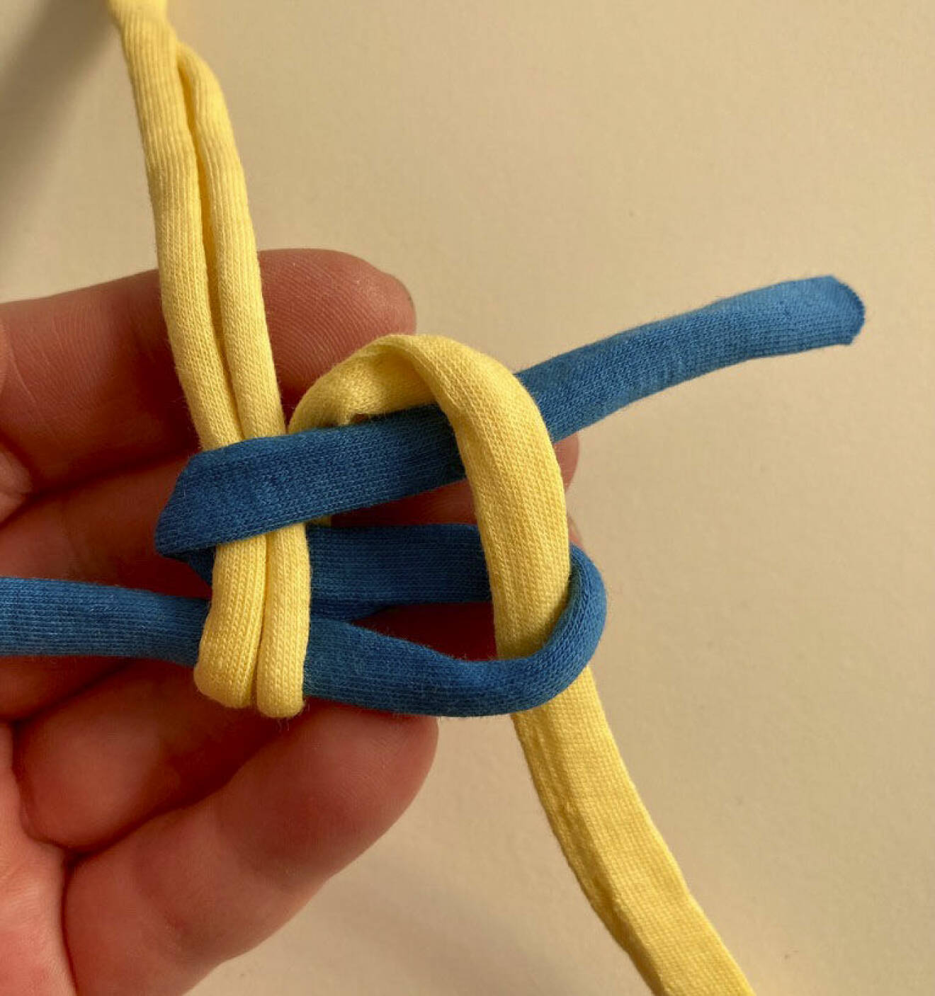 Blått och gult band flätas ihop till en knop