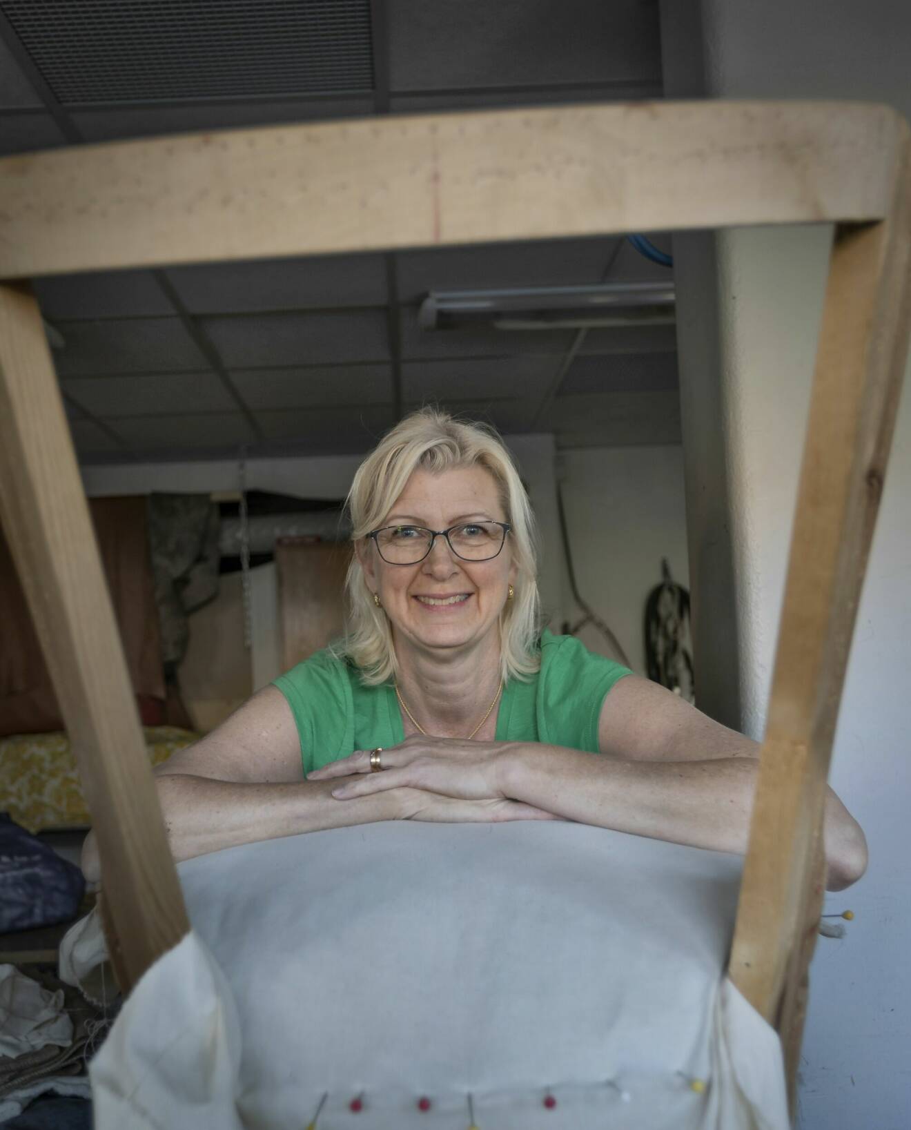 Möbeltapetseraren Petra Dolk tittar igenom en stol som för tillfället saknar rygg.