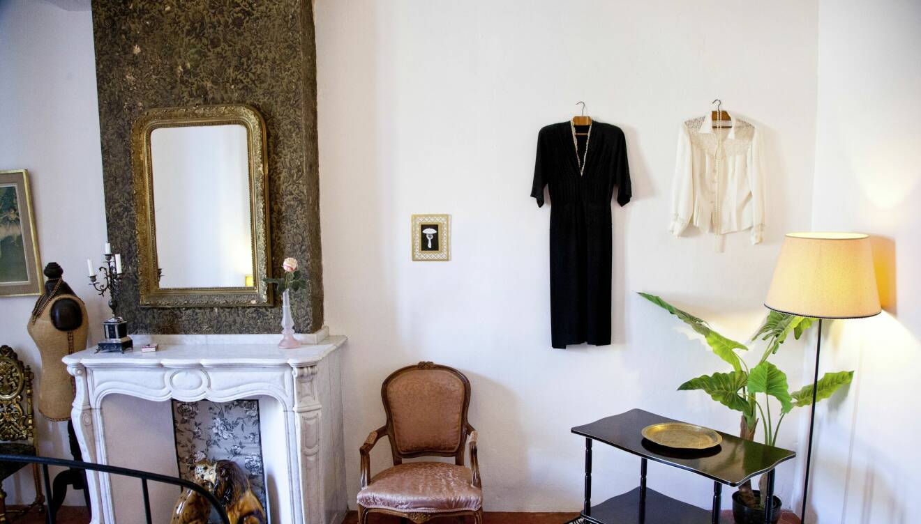 I Coco Chanel-rummet bredvid en eldstad hänger klänningar på väggen av den berömda designern och på andra sidan eldstaden står en provdocka.