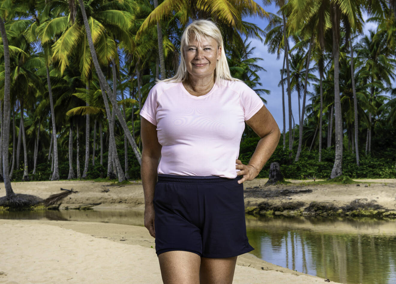 Eva Andersson, en av deltagarna i Robinson 2022, fotograferad på en strand bland palmer.