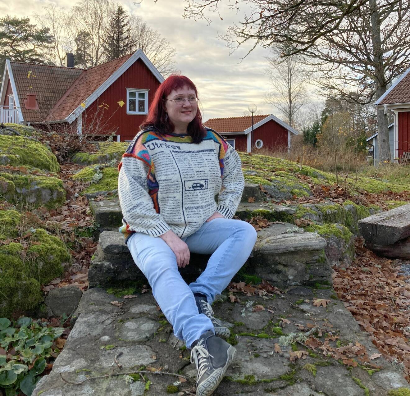 Ingela Wadbring, professor och författare, sitter på en klippa utanför sitt hus i Alingsås.
