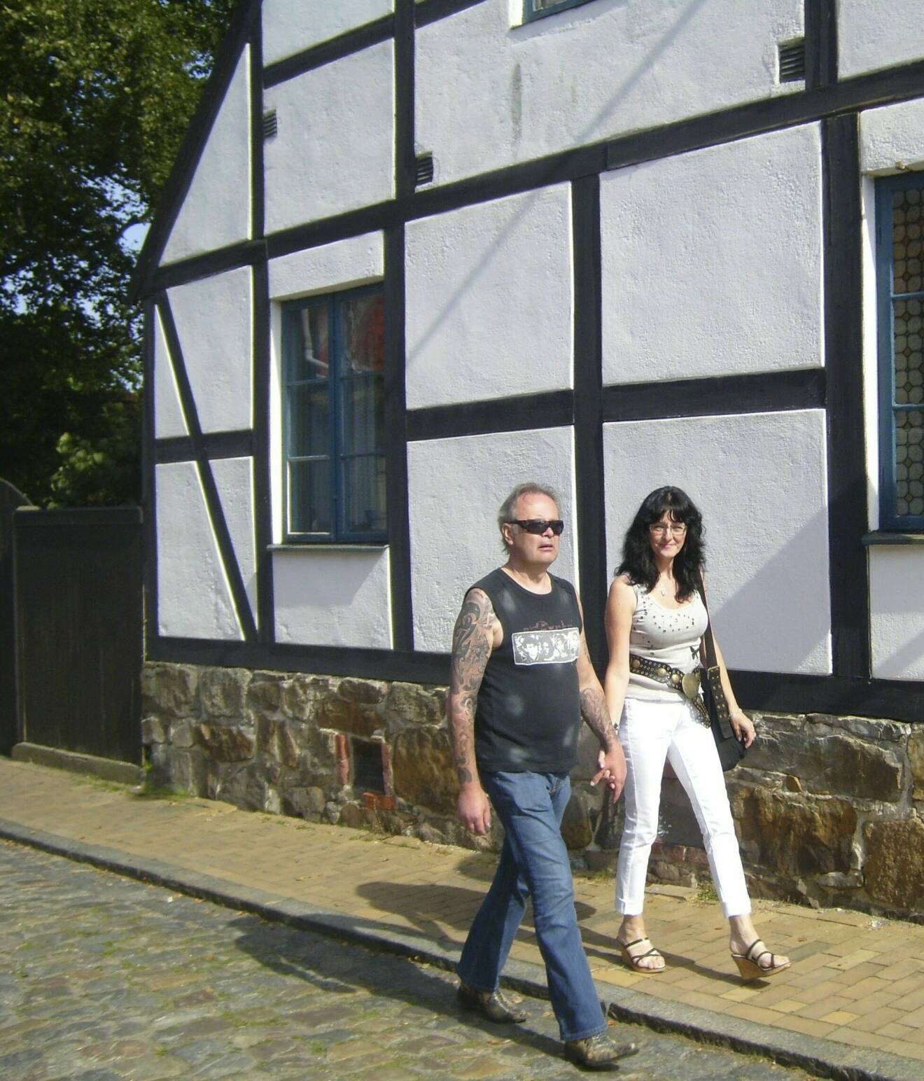 Kent och Eva vandrar hand i hand förbi ett korsvirkeshus i Simrishamn. Året är 2007.