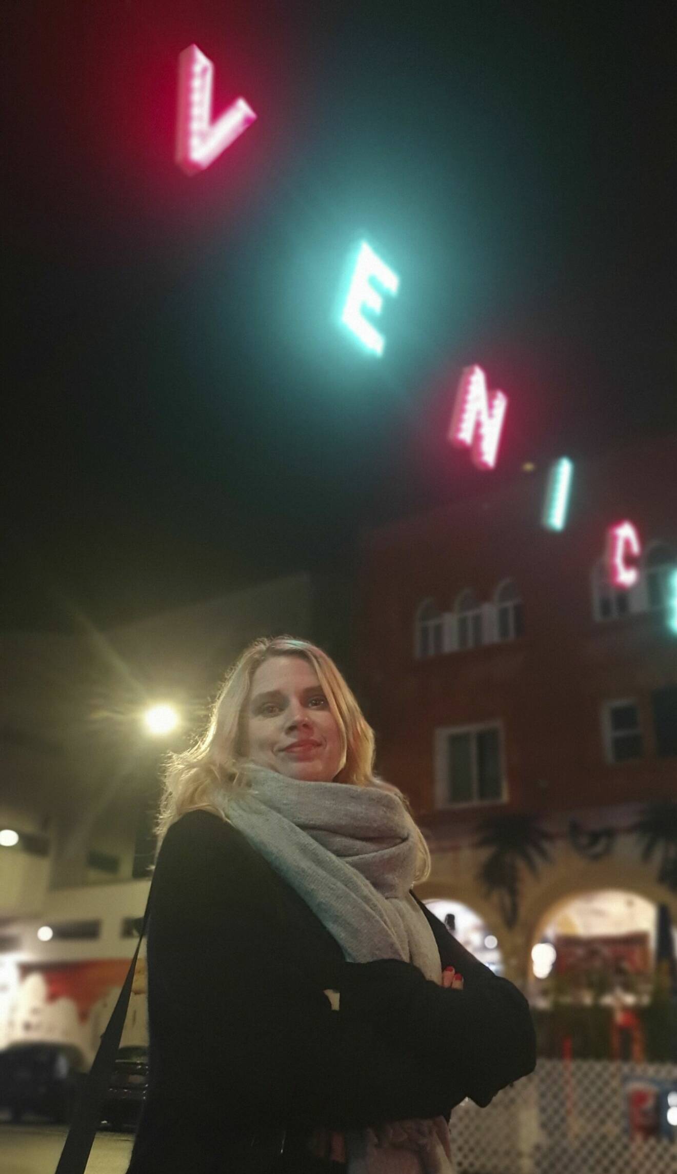 Författaren Sofie Weidemann under neonbokstäver som säger Venice.