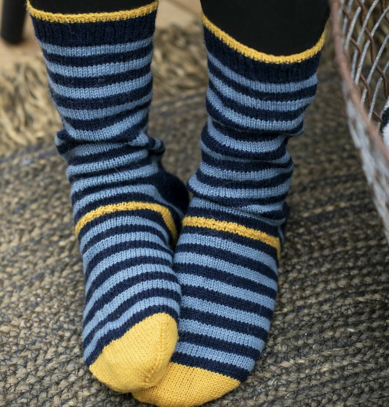 Stickade randiga strumpor med en gul mönsterstickad rand.