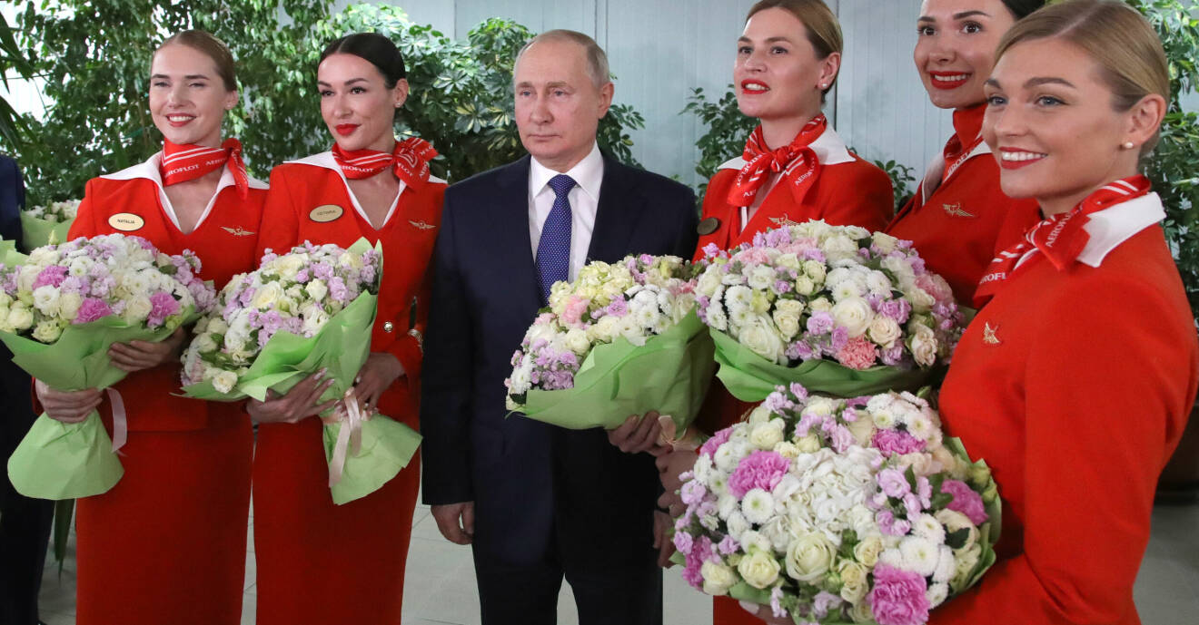 Vladimir Putin omgiven av flygvärdinnor.