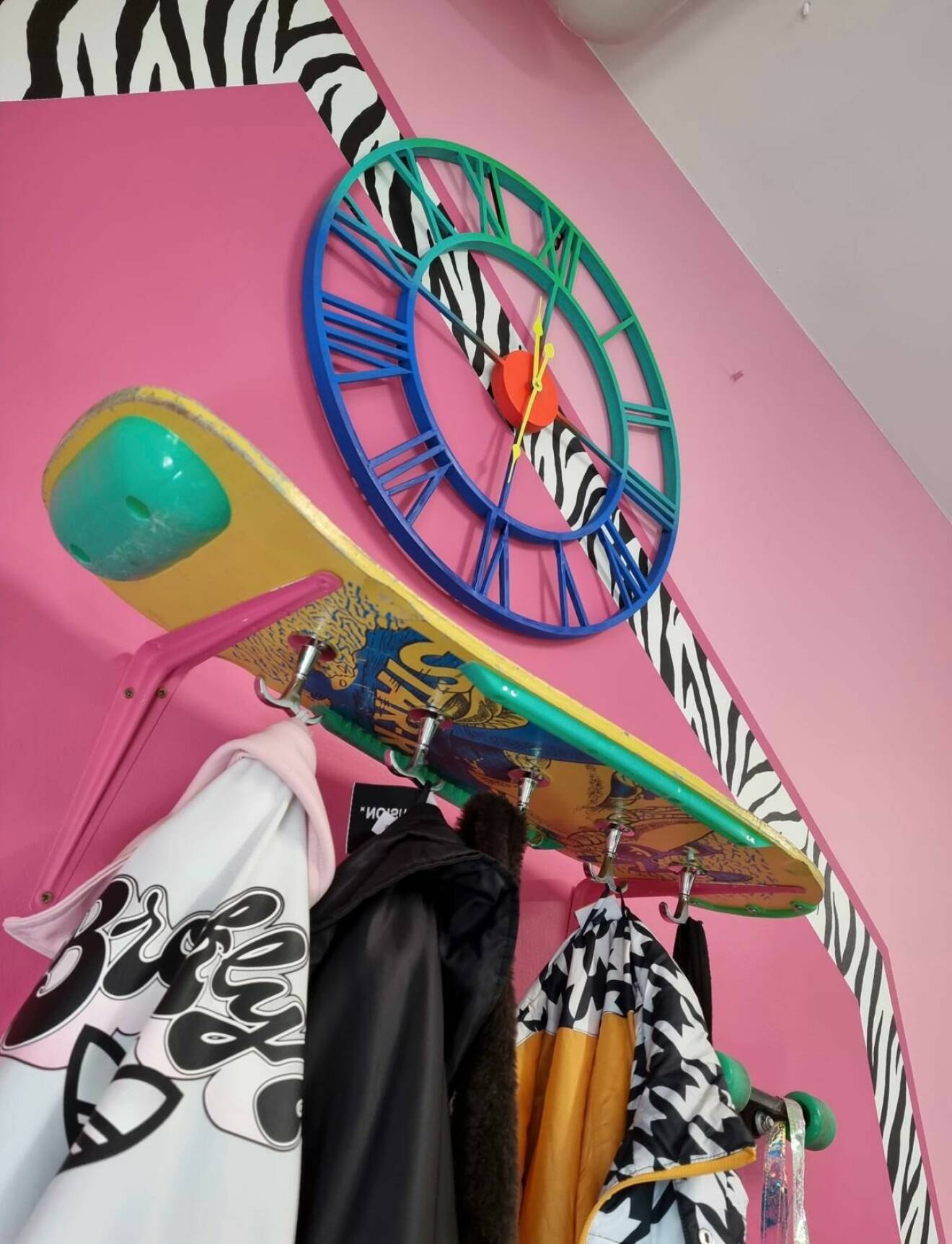 En färggrann skateboard som fungerar som klädhängare.