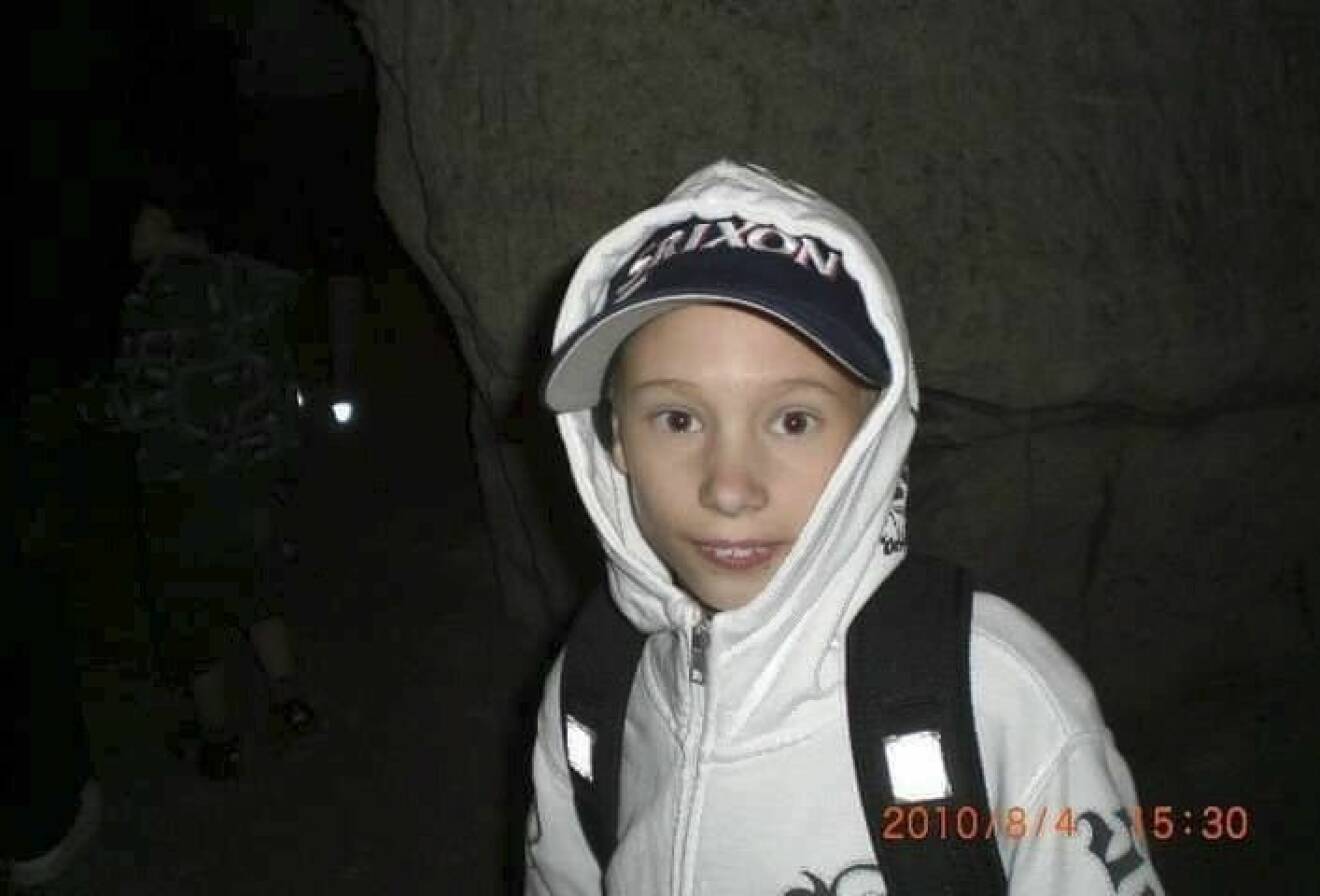 En pojke i yngre tonåren med keps och luvtröja.