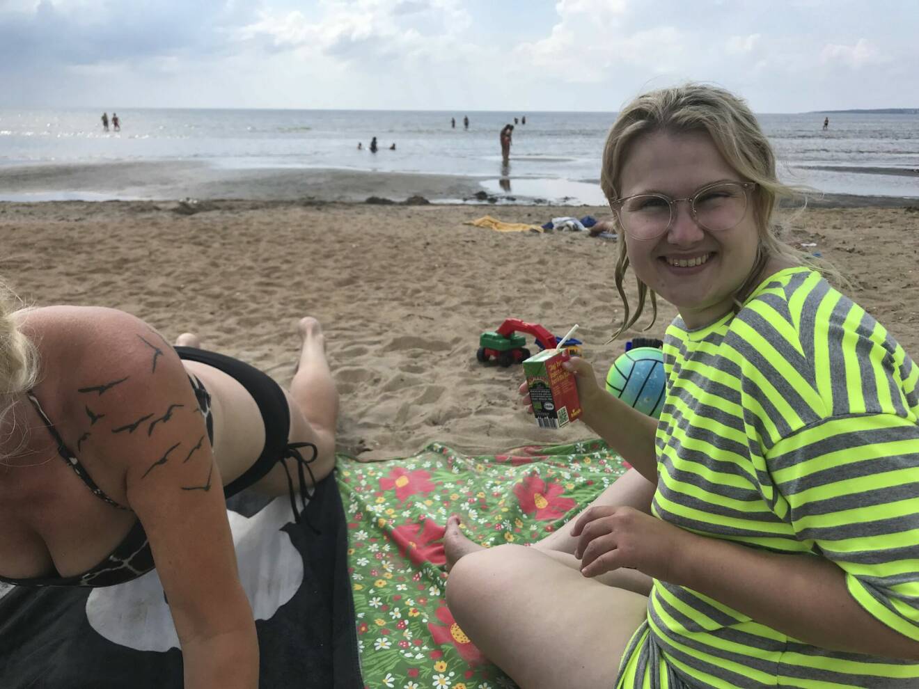 Skådespelaren Emma Örtlund på en svensk strand med en Smakis i handen.