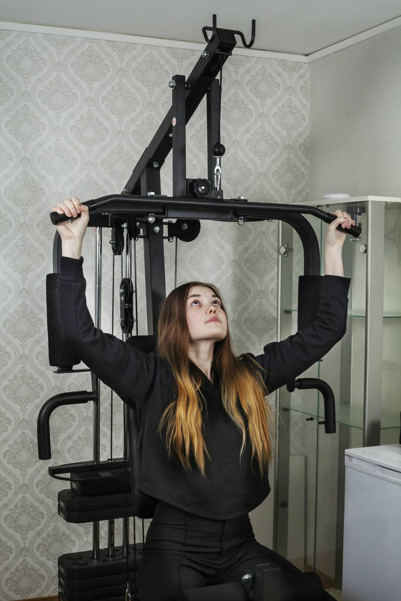 Tilde sitter i en träningsmaskin och berättar att hon måste träna varje dag för att orka med vardagen.