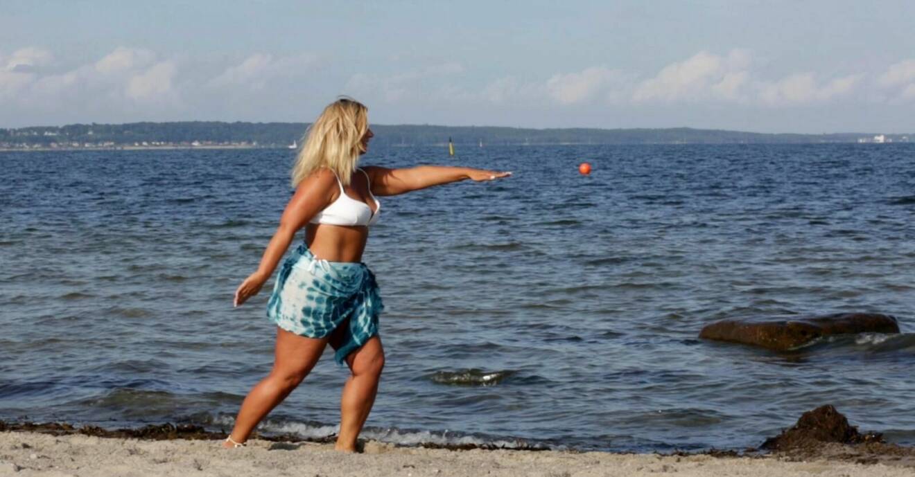 Kvinna tränar på stranden.