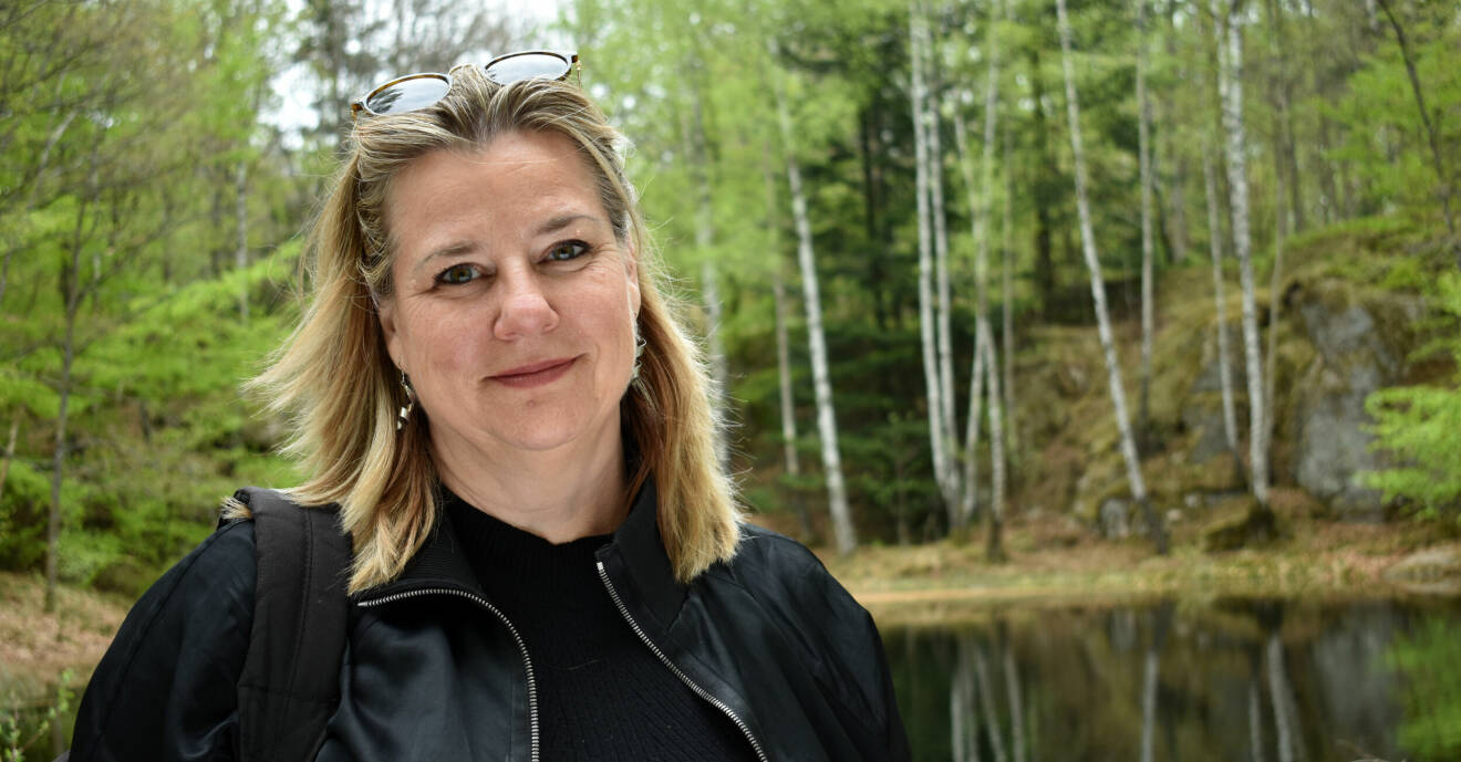 Anna Carlstedt fotograferad framför en liten sjö inne i en vårgrön skog.
