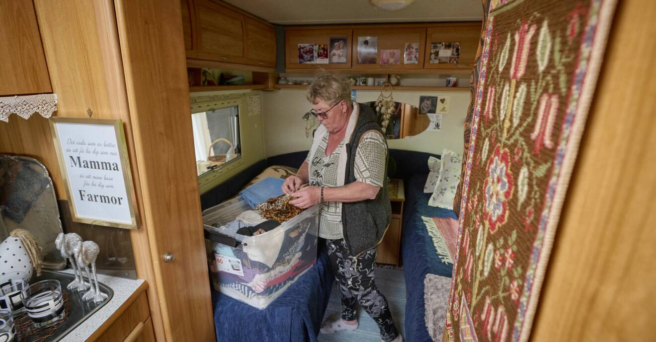 Liselott sorterar kläder i en låda i sovdelen av husvagnen som består av två sängar istället för en stor.