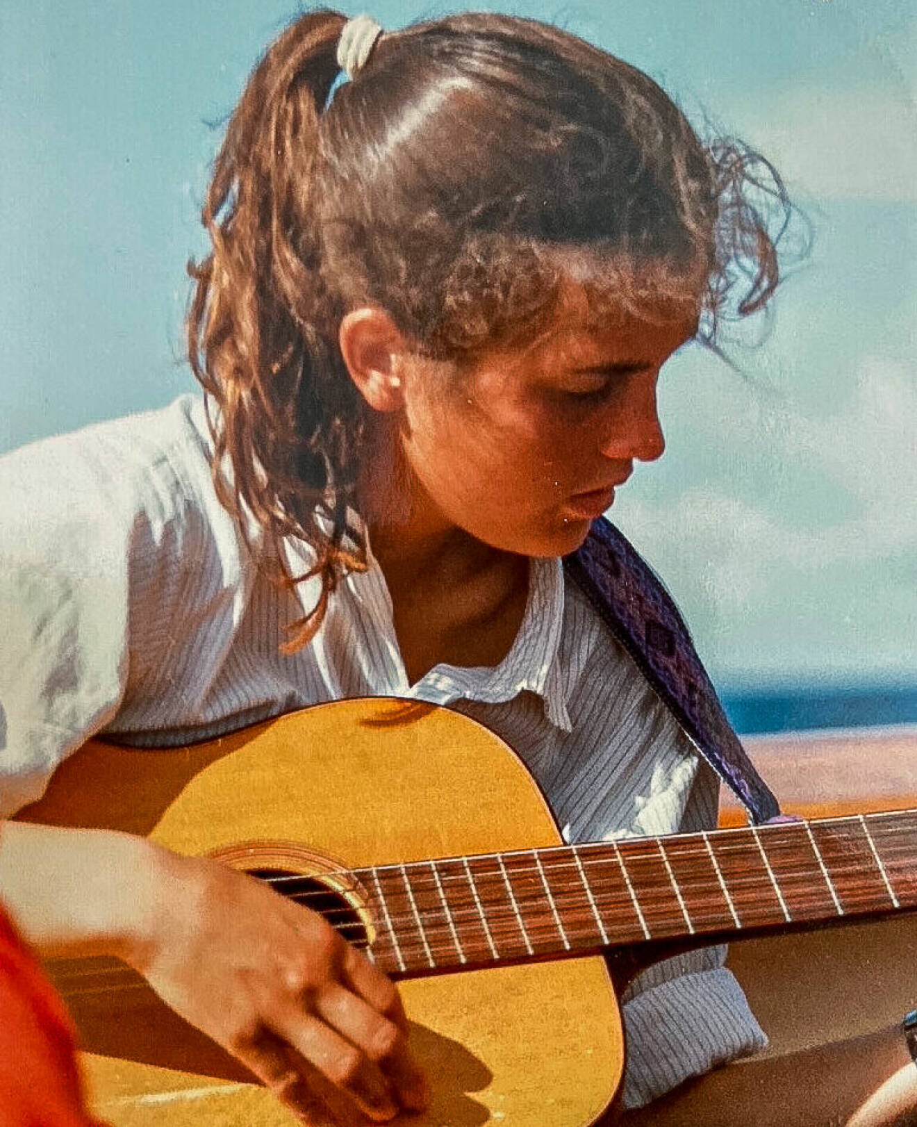 En ung Pia med gitarren.