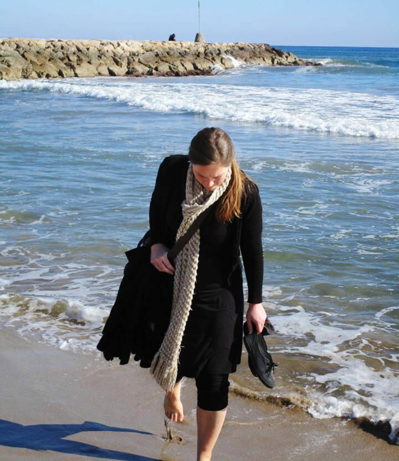 Ann-Helén Andersson går på stranden vid vattenbrynet i Sitges som ligger några mil utanför Barcelona, staden där hon bodde i ett och ett halvt år.