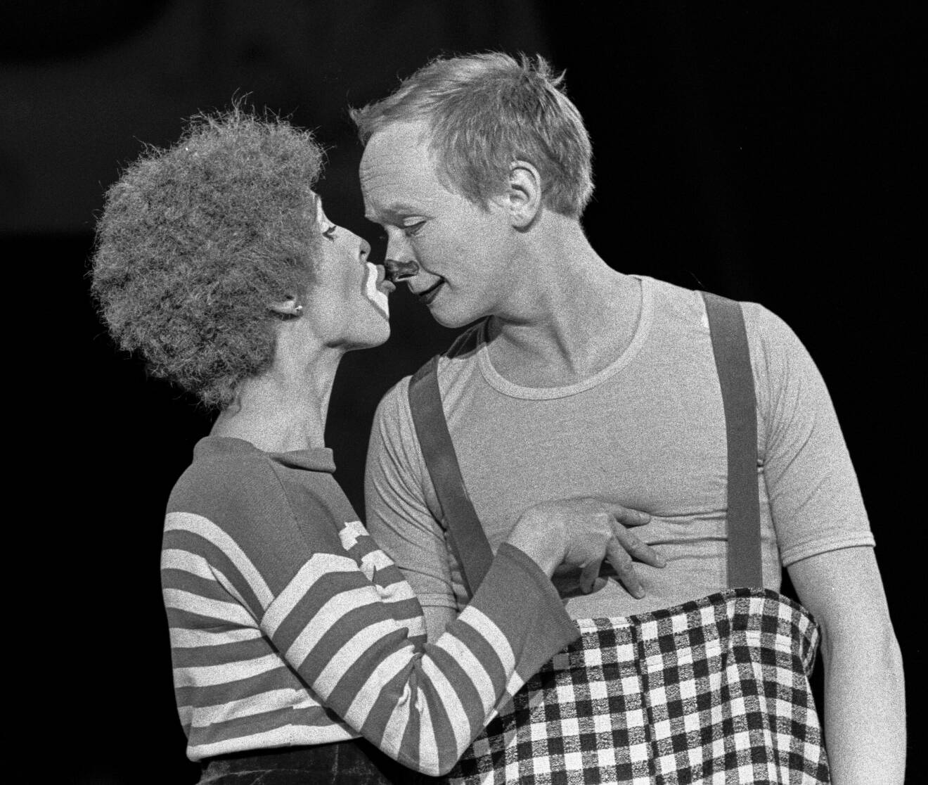 Svartvit bild på Eva Rydberg som pussar Lasse Kühler på näsan. Båda är utklädda till clowner och uppträder på Cirkus Scott 1975.