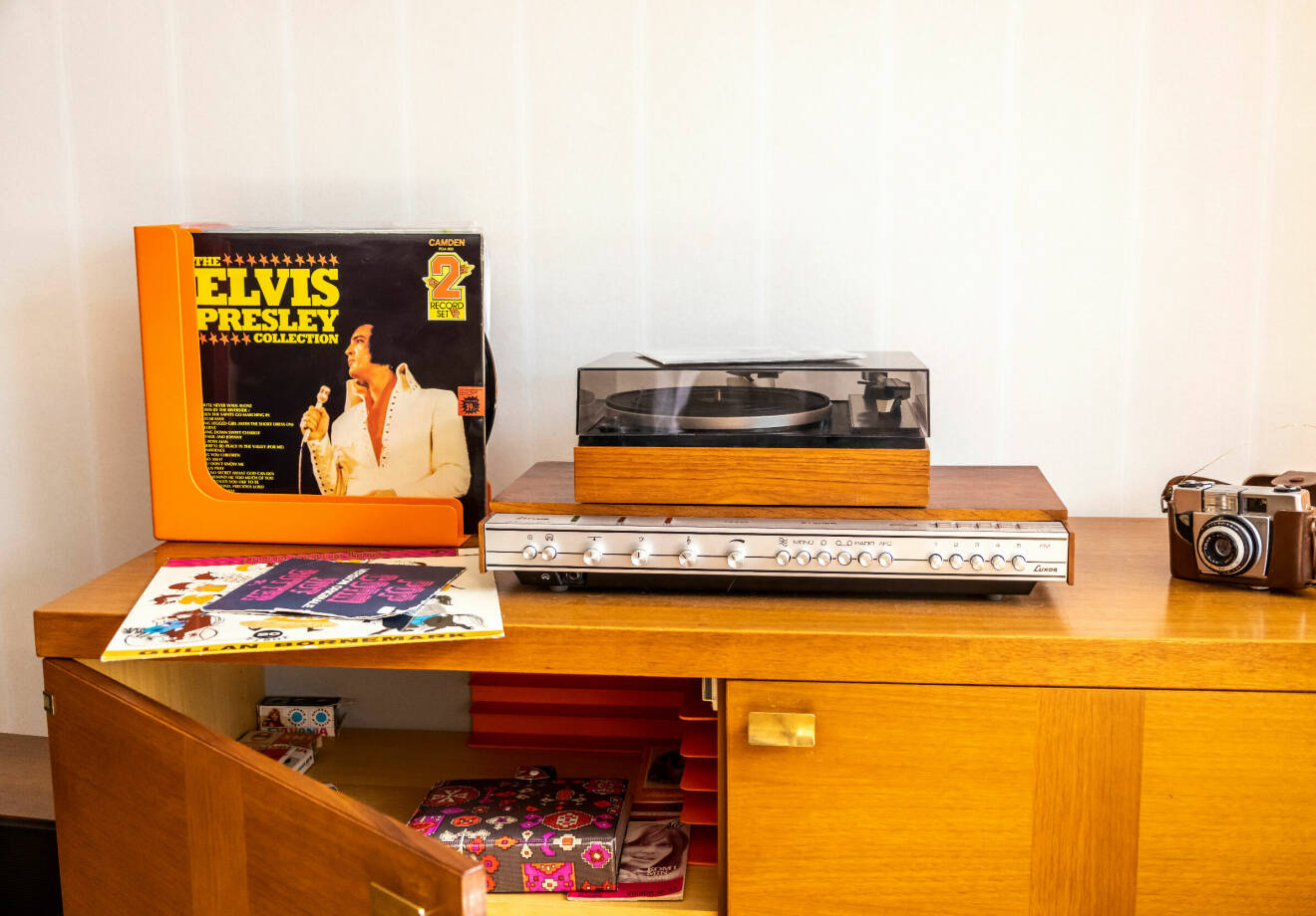 Skåp från 70-talet med grammofonspelare, en gammal skiva med Elvis Presley och en gammal analog kamera.