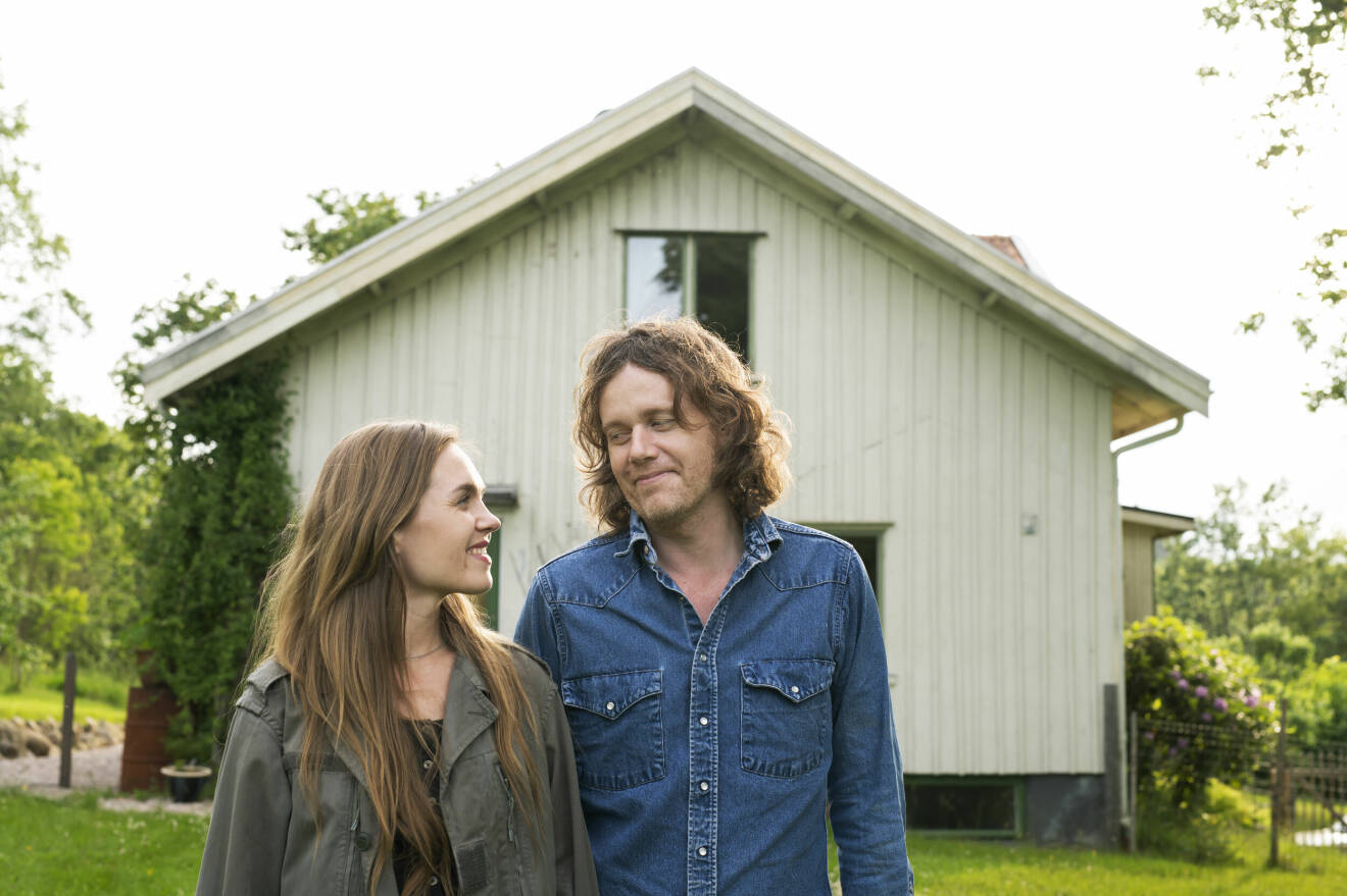 Musikerna Ann-Sofie och John Hoyles framför sitt ljusgröna hus i Öxabäck.