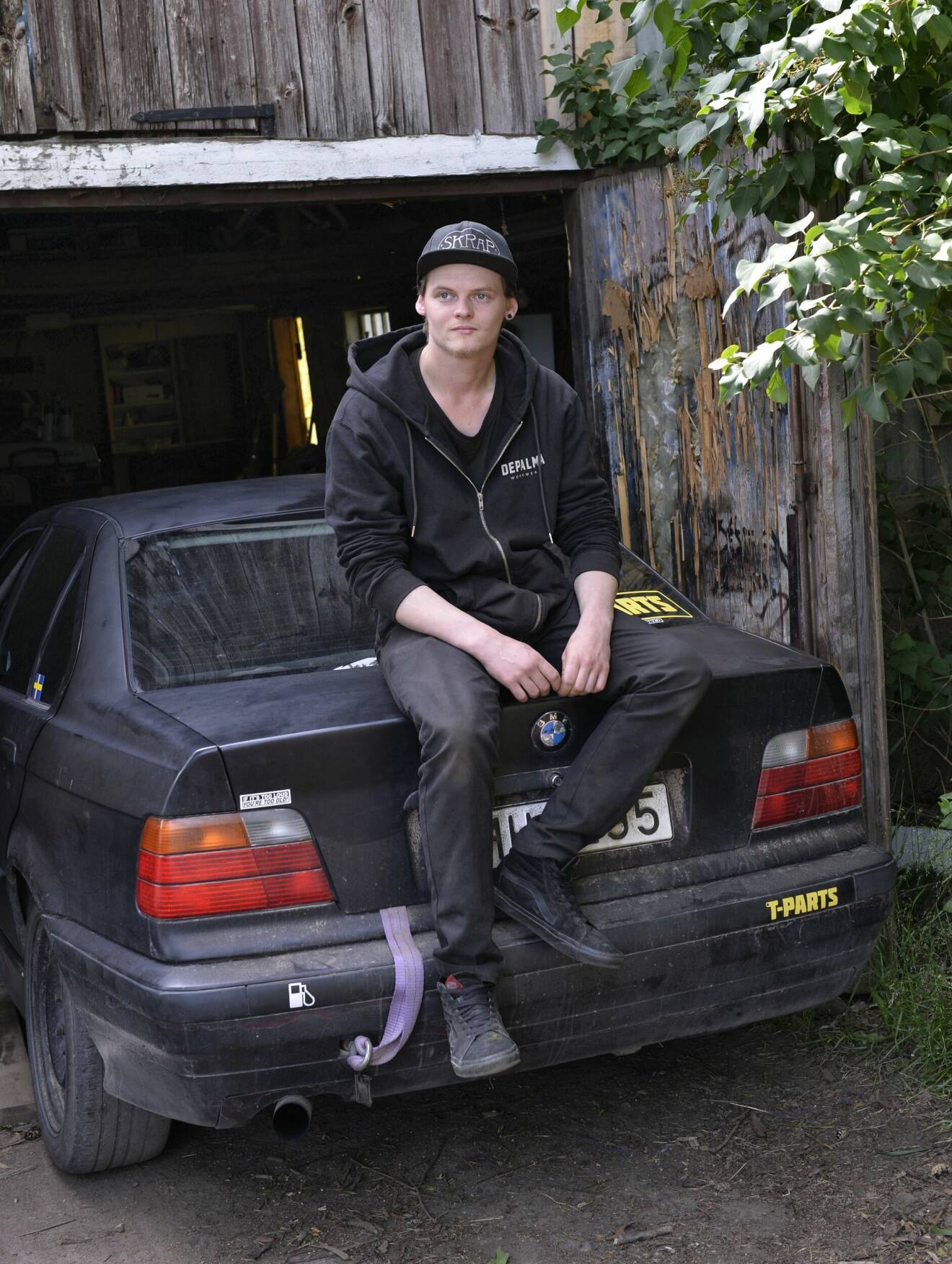 Victor Rydén, 22 år, sitter på sin bil.