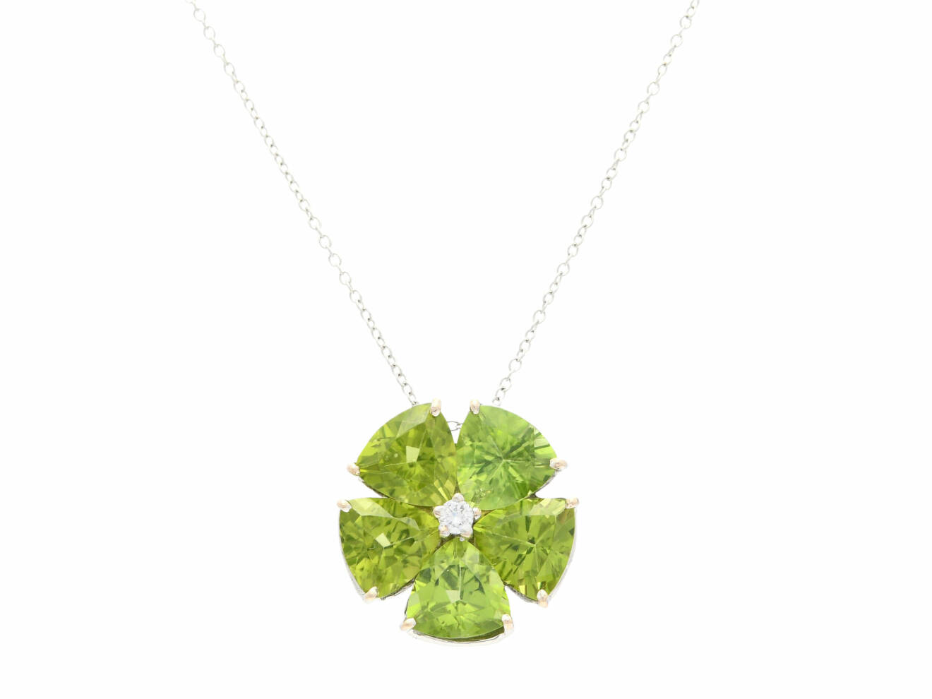 Ett grönskimrande hänge av 18 k vitguld med fem triangelslipade peridoter och briljantslipade diamanter.