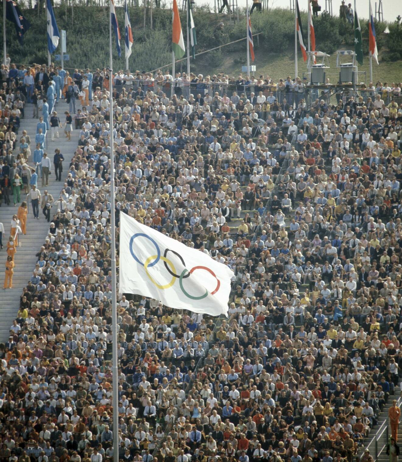 Flaggor på halv stång och en massa publik på läktare på OS i München 1972.