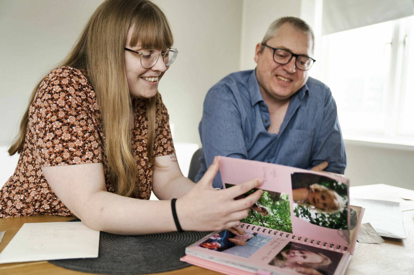 En ung kvinna och hennes pappa, tittar i ett fotoalbum.