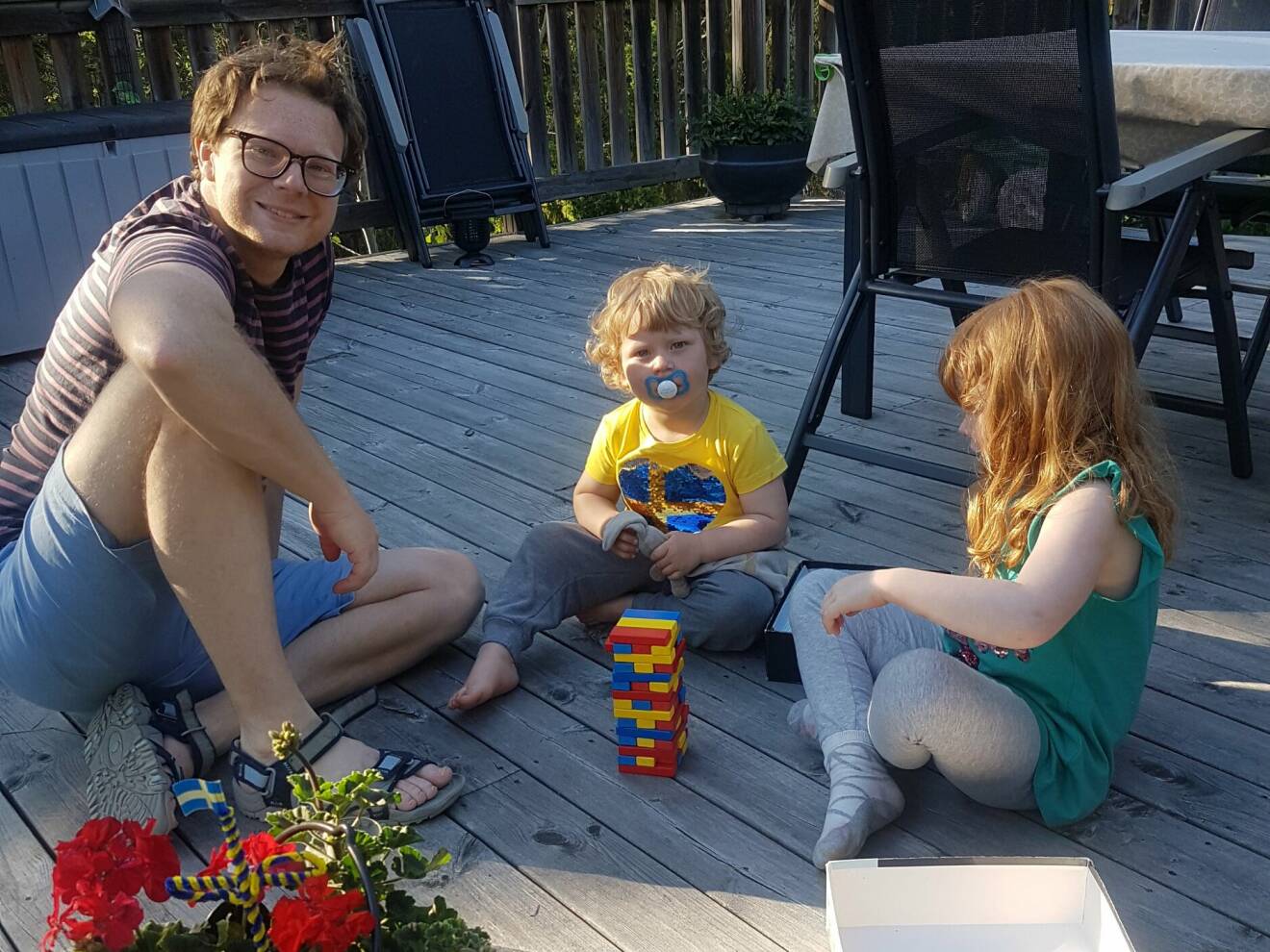 Foto från tiden då Magnus var frisk och leker med sina barn på terrassen.