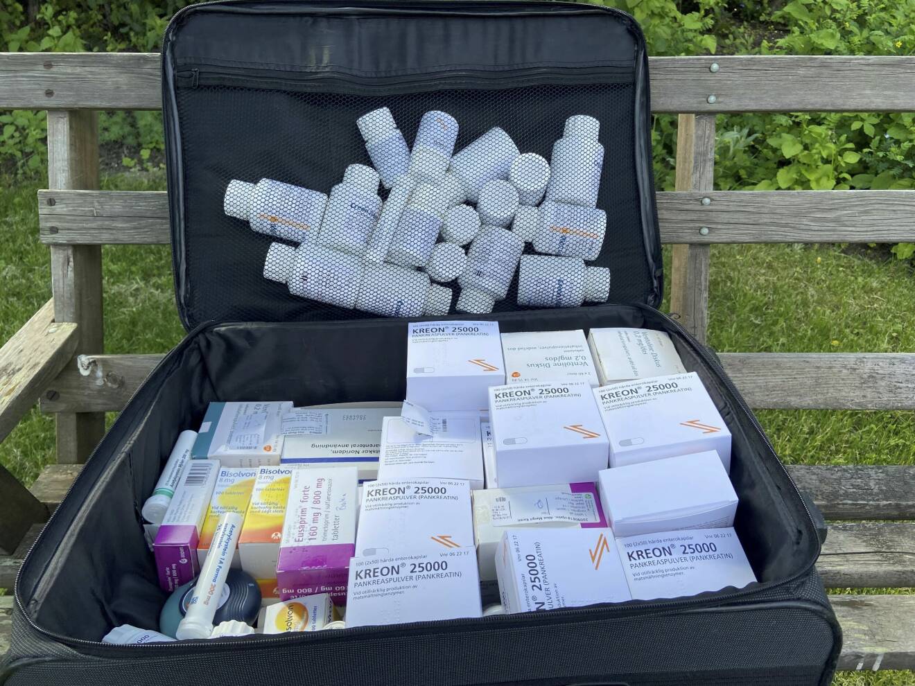 Resväska fylld av olika mediciner.
