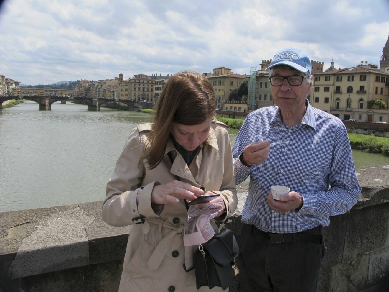 Författaren Charlotte Al-Khalili läser en karta på en bro i Florens, bredvid står hennes pappa och äter glass.