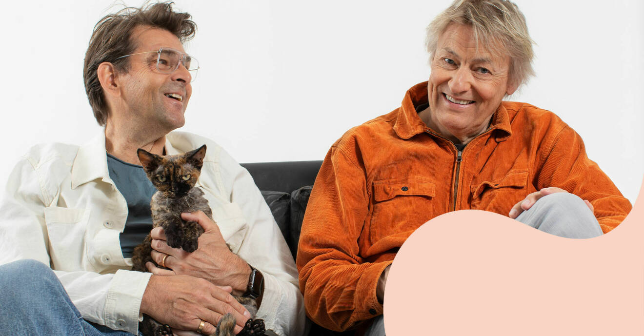 Niklas Strömstedt och Lars Lerin sitter bredvid varandra i en soffa. Niklas håller katten Kerstin i famnen.