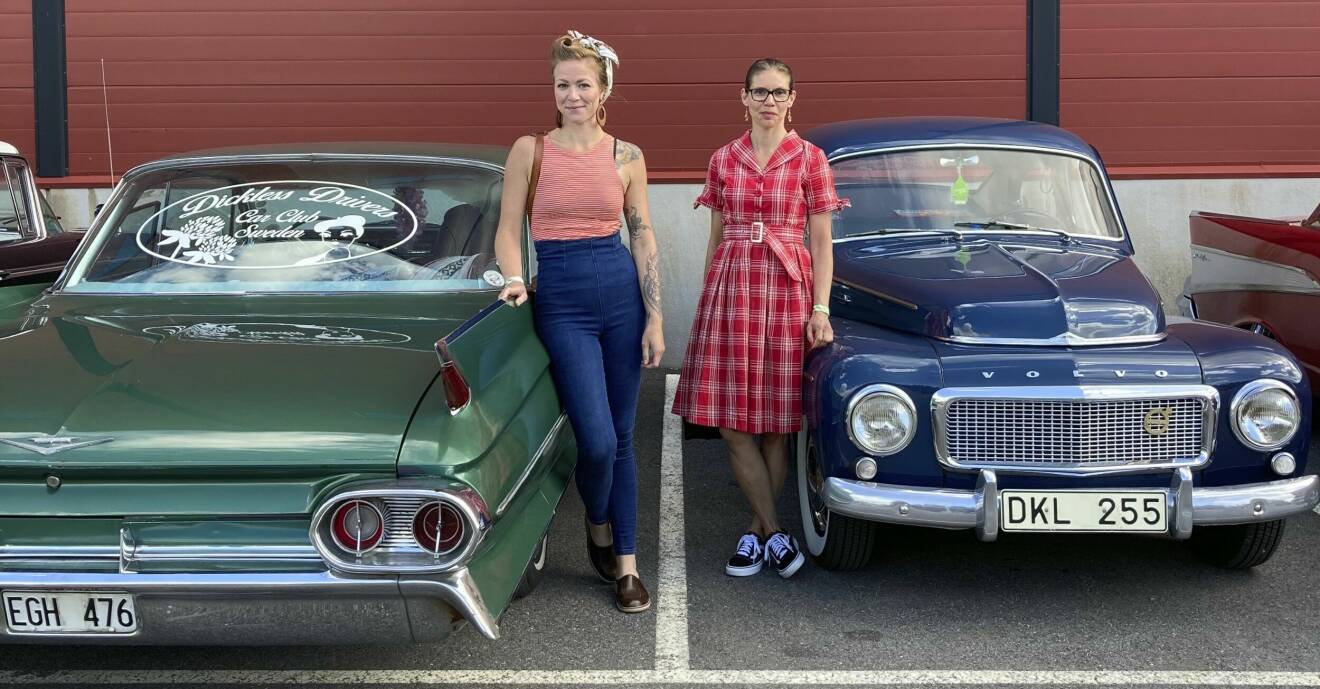 Julia Lind och Annelie Sundberg i retrokläder framför sina veteranbilar, en grön Cadillac coupé Deville och en blå Volvo PV.
