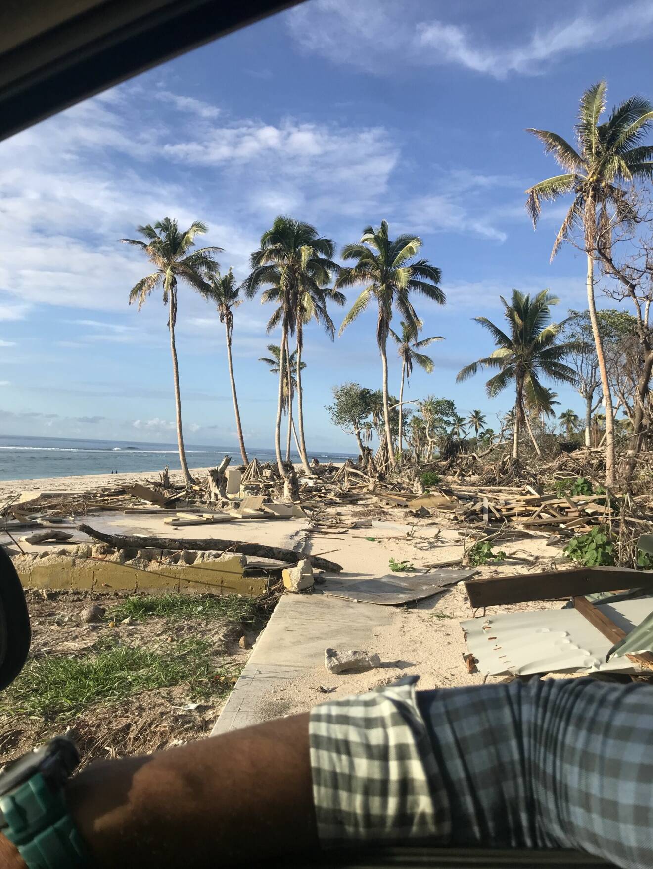 Massa bråte bland palmer på strand i Tonga.