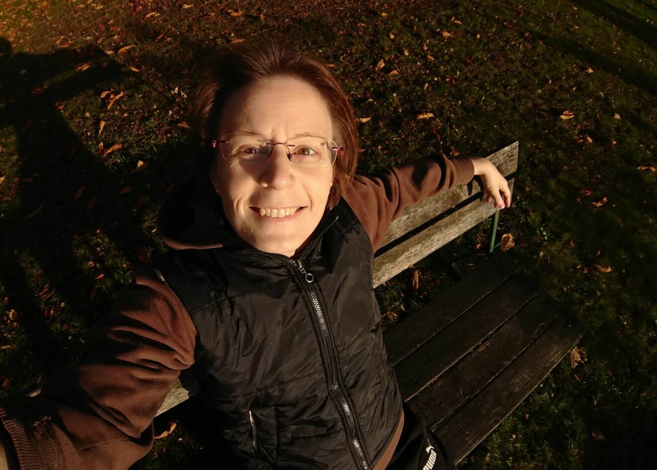 Selfie på en leende Bianca Zenonsson som sitter utomhus på en parkbänk.