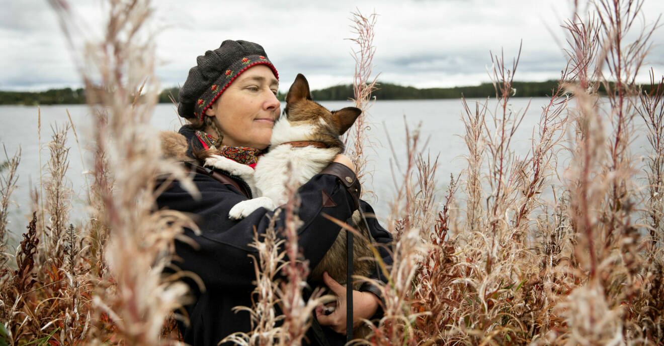 Alexandra kramar om hunden Ronja framför en sjö.