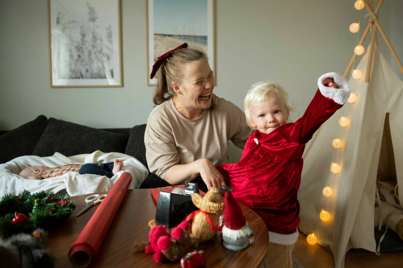 Jenny Larsson, som har en cp-skada, klär på sin dotter Astrid en tomteklänning och skrattar.