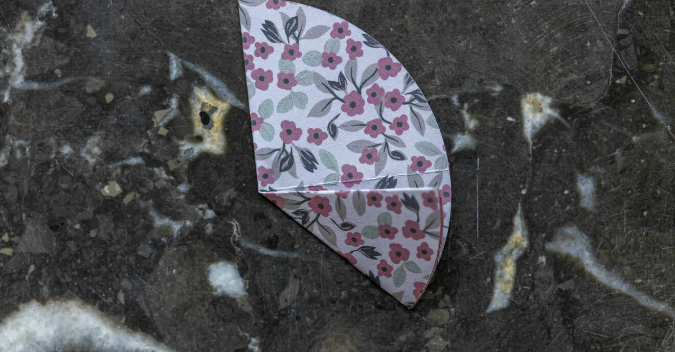 Blommigt vikt papper på en marmorskiva