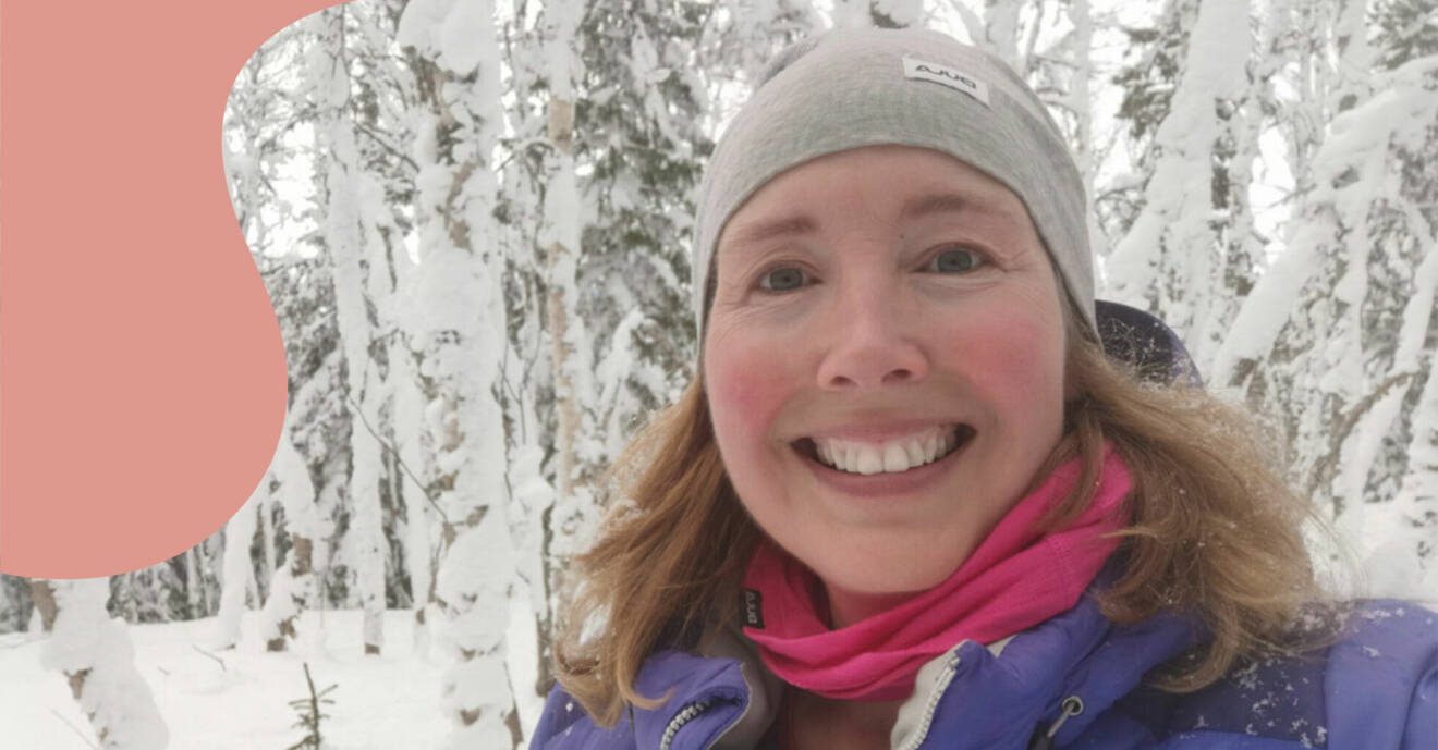 Porträttbild på Camilla. Det är vinter och snö i bakgrunden. Camilla ler och har på sig en grå mössa, lila jacka och rosa halsduk.