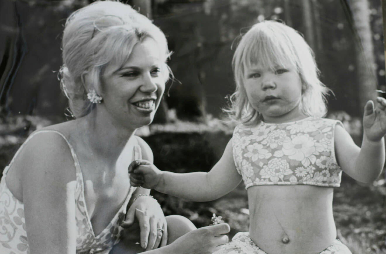 En kvinna med en liten flicka, det är 1960-tal och de har badkläder på sig.