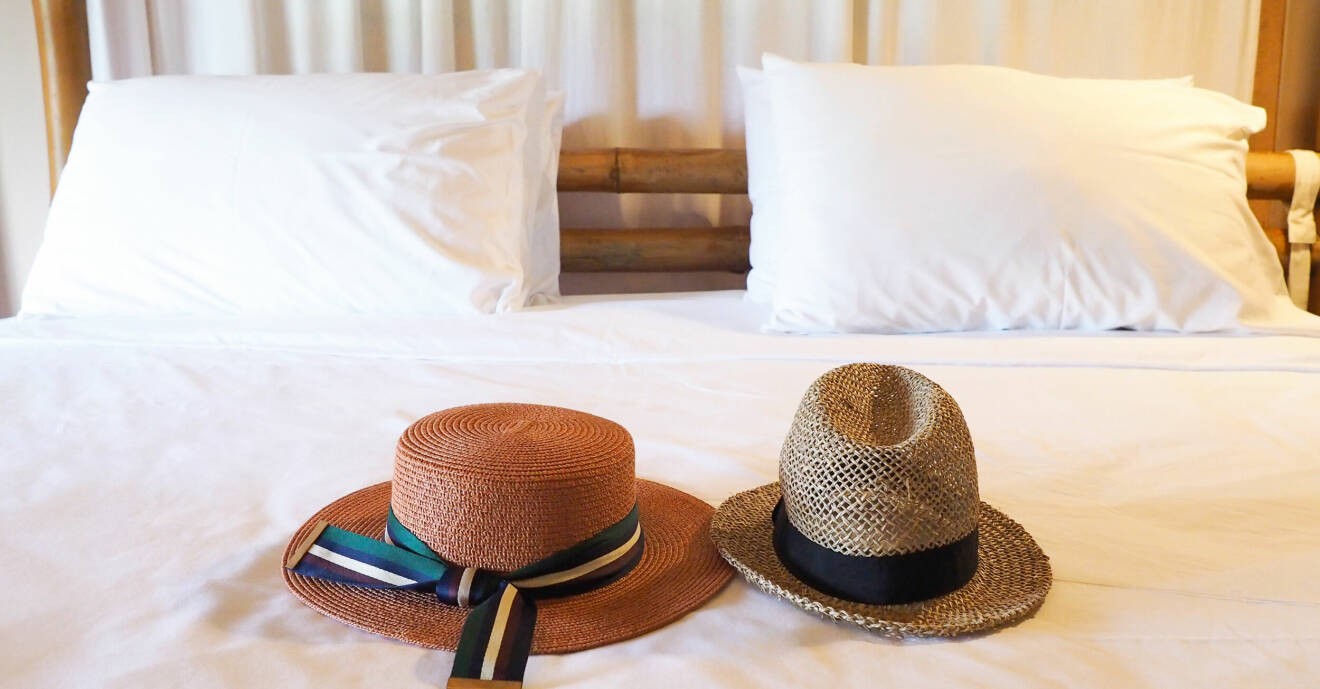 Två hattar som ligger på en säng.