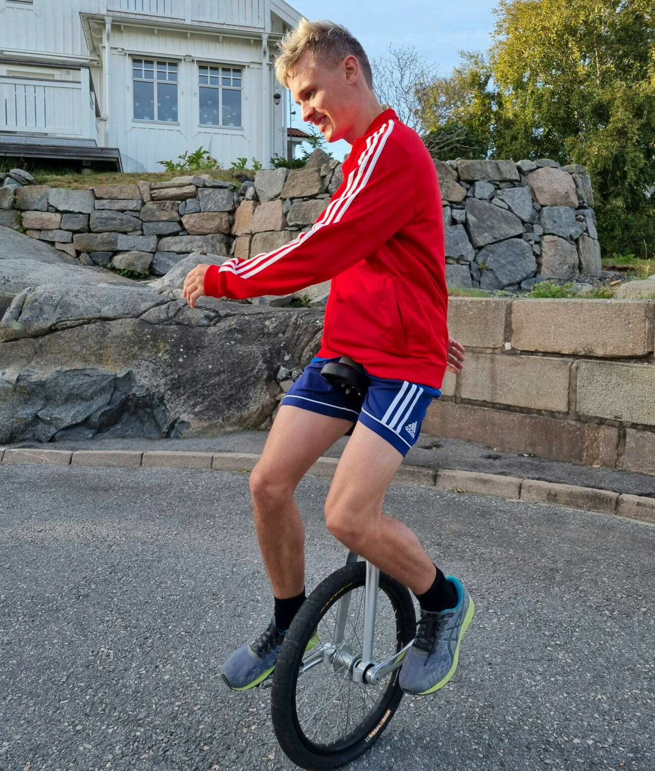 Oscar Ebenfelt cyklar enhjuling och har på sig en röd långärmad tröja.
