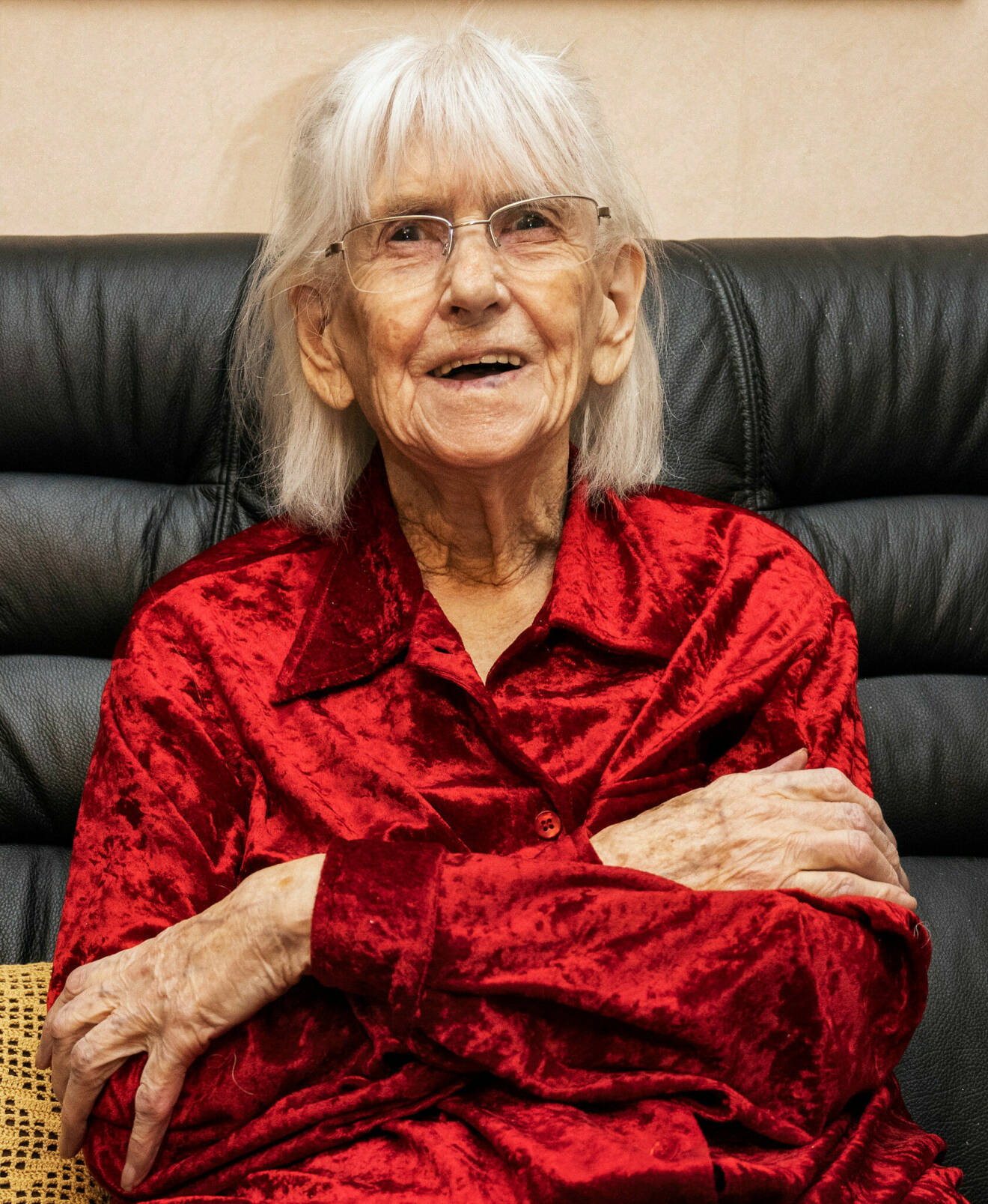 92-åriga Sara, hon har vitt hår ner till axlarna och en röd skjorta på sig.