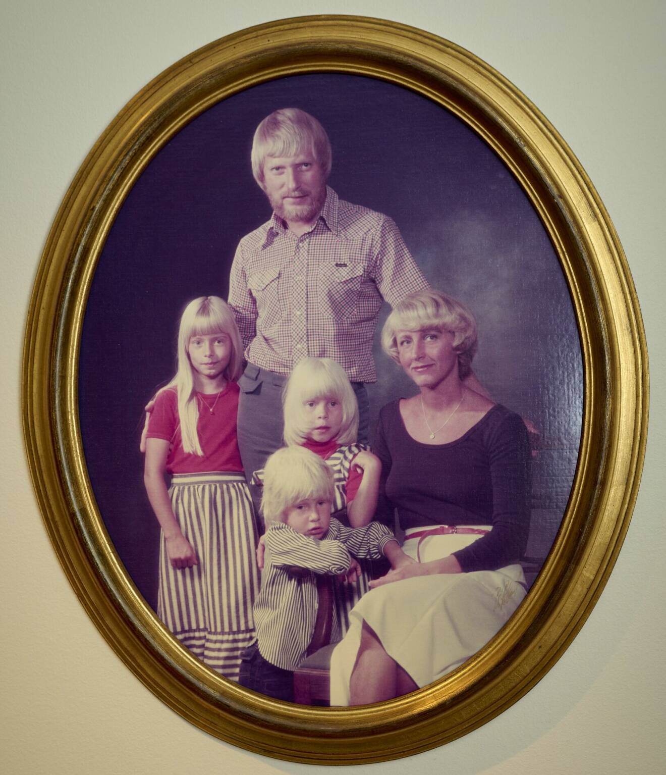 En guldram med ett äldre familjeporträtt.