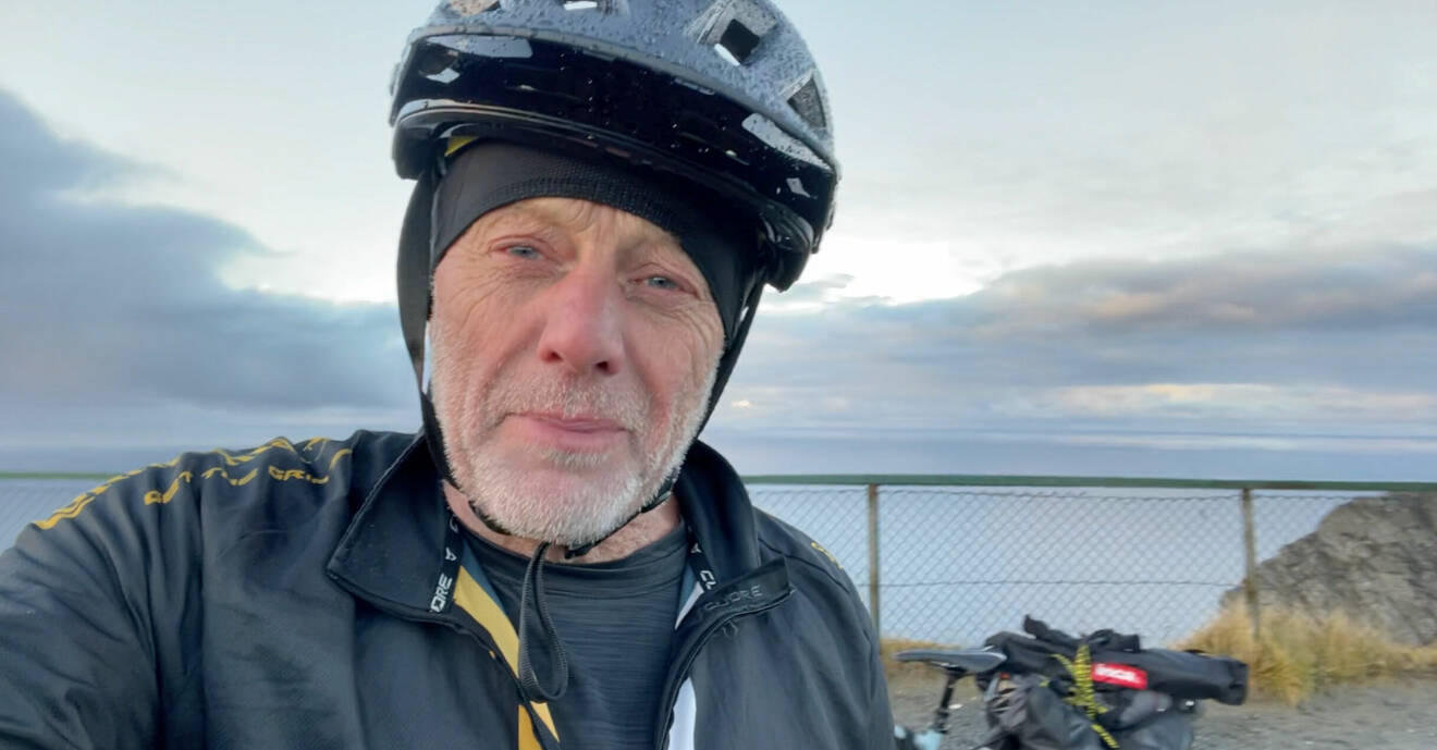Nick Sanders har på sig en svart cykelhjälm, i Nordkap, Norge.