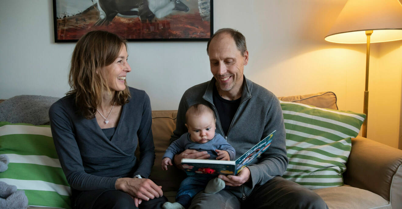 Lena Gavelin tillsammans med sambon Mikael, som håller sonen Melvin i famnen. De sitter i soffan och ser glada ut.