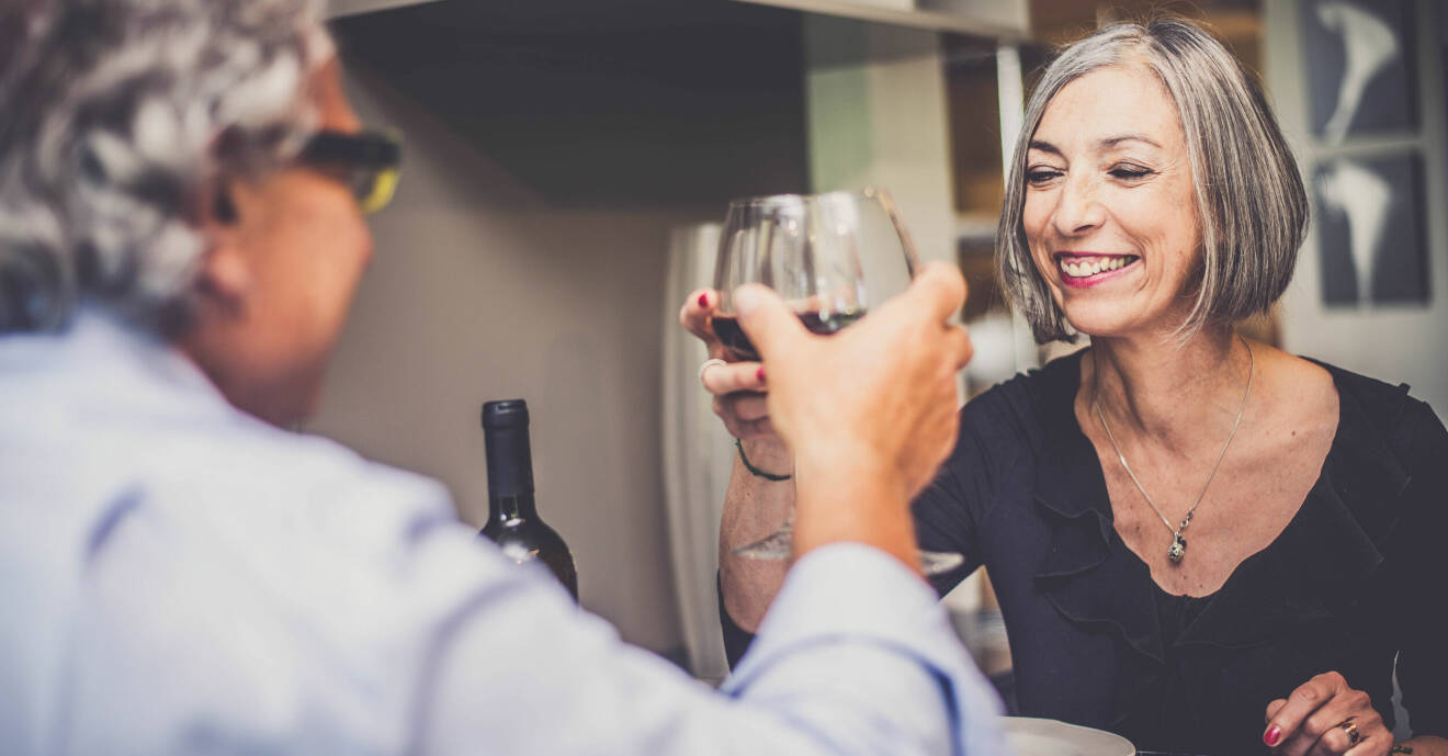 En man och en kvinna skålar med varsitt glas rödvin.S