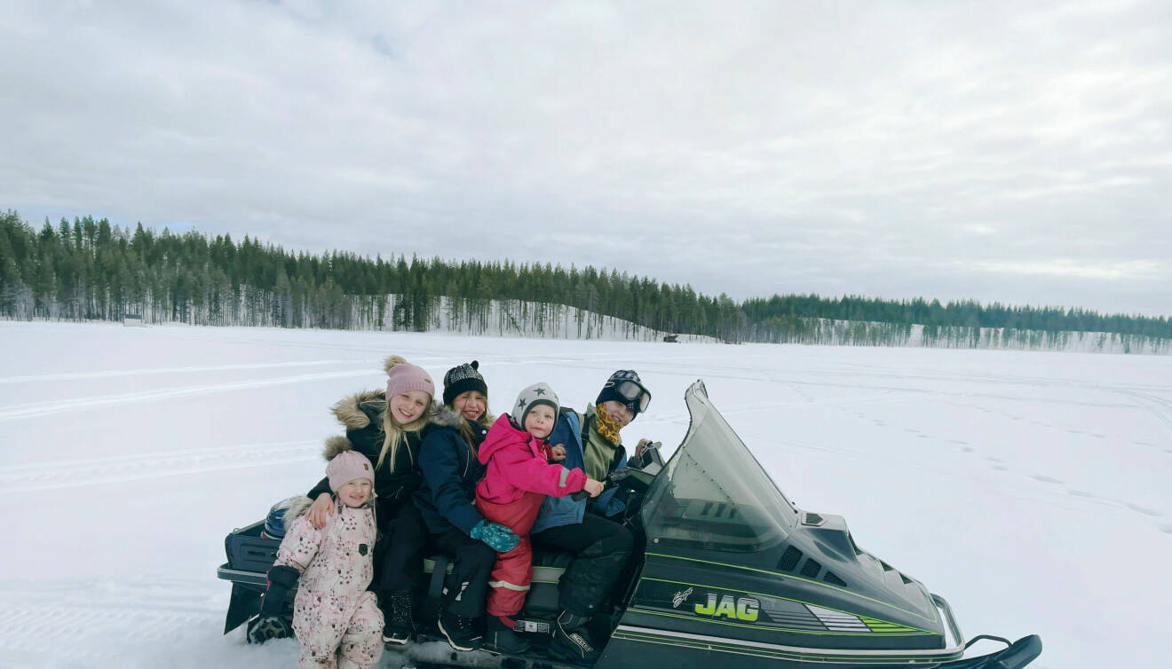 Fem barn sitter på en snöskooter.